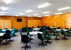 un'aula con tavoli e sedie verdi in una stanza di Parque de Campismo Orbitur Canidelo a Vila Nova de Gaia Altre 31 foto