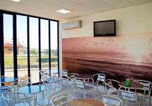 a room with tables and chairs and a flat screen tv at Parque de Campismo Orbitur Canidelo in Vila Nova de Gaia
