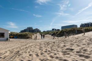 a sandy beach with a few cars parked on it at de Baak Seaside in Noordwijk aan Zee