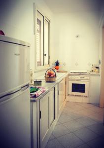 a white kitchen with a bowl of fruit on the counter at Casa Vacanze Zia Titina in Trabia