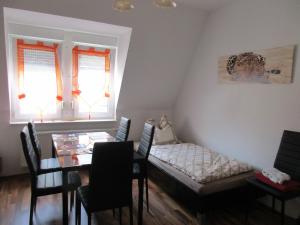 comedor con mesa, cama y ventanas en Maisonette /Fewo Kopp III, en Greiz