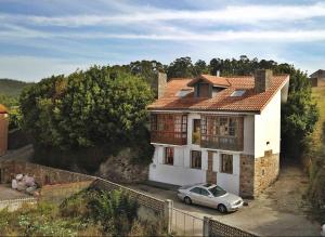 una casa con una macchina parcheggiata di fronte di Casa Estrella de Garda a Buño