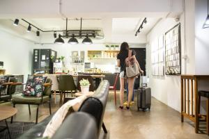 una mujer de pie con una maleta en un restaurante en We Come Hostel, en Taipéi