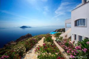 un edificio con flores junto al agua en Slow Luxury Patmos Villas Sophia and Tatyana with private pools en Grikos