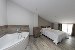 a bedroom with a bed and a bath tub at Hotel Asador O Callejón De Belchite in Ayerbe