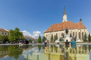 a group of people sitting around a fountain in front of a building at Köte Haus in Cluj-Napoca