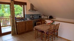a kitchen with a table with chairs and a table and a window at Oak Tree Apartment - Tölgy Lak Apartman és Szauna in Pilisszentkereszt
