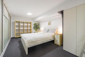 a bedroom with a white bed and a yellow cabinet at Duplex Urban Apartment in Ljubljana