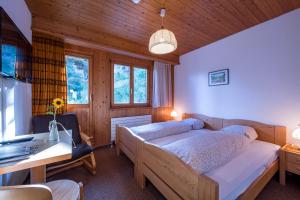 a bedroom with a bed and a desk in a room at Berghotel Sellamatt in Alt Sankt Johann