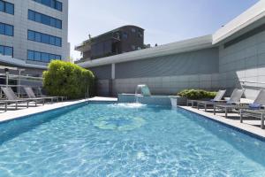 a swimming pool with a fountain on a building at Hotel SB Icaria in Barcelona
