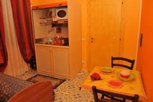 - une petite cuisine avec une petite table, une table et des chaises dans l'établissement Albergo Roses, à Paola