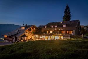 une grande maison au sommet d'une colline la nuit dans l'établissement Berghotel Sellamatt, à Alt Sankt Johann