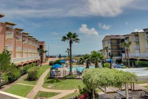 a view of a resort with a pool and palm trees at The Victorian in Galveston