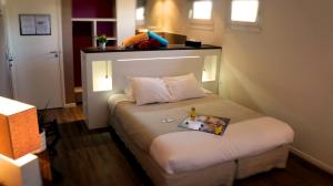 een slaapkamer met een bed met een boek erop bij Hotel-Restaurant Lann Roz / Côte Cuisine in Carnac