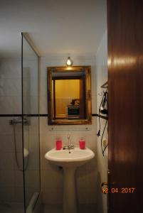 a bathroom with a sink and a mirror and a shower at Villa Eora in Keri