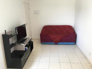 Habitación pequeña con cama y TV. en Apartamento-Excelente localização, en Resende