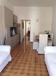 リーパリにあるCasa vacanza Lipariの白い家具とウッドフロアのリビングルーム