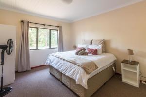 a bedroom with a large bed with a window at Kamberg Valley Hideaway in Kamberg Valley