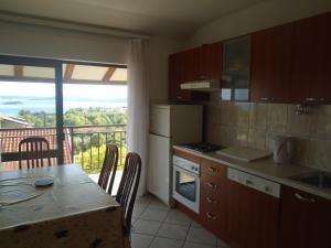 a kitchen with a table and a view of a balcony at Apartments Sveti Anton in Orebić