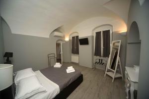 a bedroom with a bed and a table and a desk at Relais Virginia Home in Sanremo