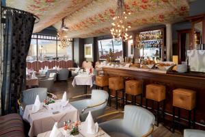 a restaurant with white tables and chairs and a bar at Hotel Parc Beaux Arts in Luxembourg