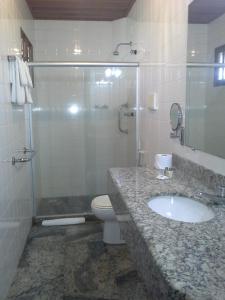 a bathroom with a sink and a shower and a toilet at Hotel La Dolce Vita in Ilhéus