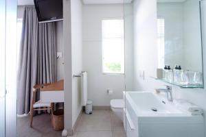 a white bathroom with a sink and a toilet at Thirty On Grace in Cape Town