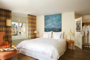 Un dormitorio con una gran cama blanca y una ventana en Hotel Parc Beaux Arts en Luxemburgo