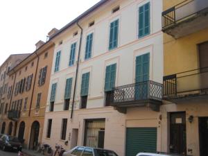 un grande edificio bianco con porte e finestre verdi di Via Aselli Liberty Palace a Cremona