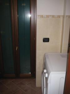 bagno con porta a vetri e lavatrice di Via Aselli Liberty Palace a Cremona