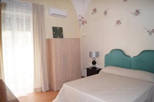 um quarto com uma cama com uma cabeceira azul e uma janela em Al primo piano bed And breakfast em Foggia