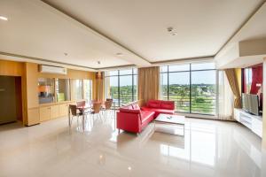 una gran sala de estar con un sofá rojo y sillas en Paradise Resort, en Norte de Pattaya