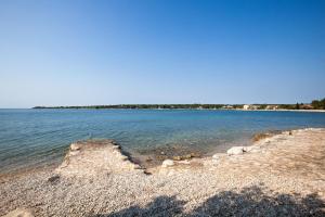 un gran cuerpo de agua con una orilla rocosa en Daila Apartments, en Novigrad Istria