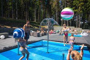 Grupa dzieci bawiąca się piłką plażową w basenie w obiekcie Czarny Kamień Resort & SPA w Szklarskiej Porębie