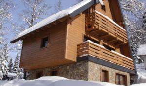 Una casa con nieve a un lado en Vila Bijela , jacuzzi & sauna, en Jahorina