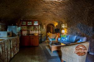 a living room with a couch and a table in a cave at Casa Cueva El Mimo in Artenara