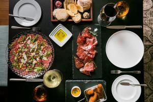 a table topped with plates of food and meat at Pousada de Lisboa - Small Luxury Hotels Of The World in Lisbon