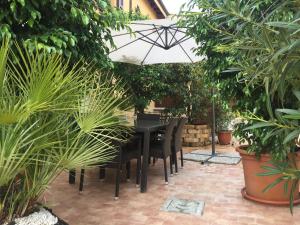 un tavolo nero e sedie con ombrellone in giardino di Casa Nives a San Pietro in Casale