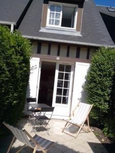 ヴィレ・シュル・メールにあるLe Cottageの家の前の椅子2脚とテーブル