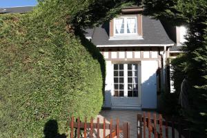 ヴィレ・シュル・メールにあるLe Cottageの白い扉と蔦の壁の家