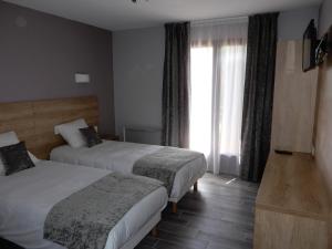 a hotel room with two beds and a window at Hotel Marinet in Châtillon-en-Michaille