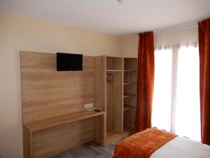 Châtillon-de-MichailleにあるHotel Marinetのベッドルーム1室(ベッド1台、壁にテレビ付)