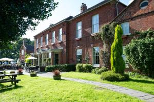 a large red brick building with a grass yard at The Hedgehog by Innkeeper's Collection in Lichfield