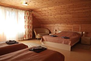 プシュキンスキエ・ゴリにあるCottage in Sharobykiのベッドルーム1室(ベッド2台、キャビン内の椅子付)