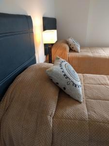 ein Schlafzimmer mit 2 Betten und einem Kissen darauf in der Unterkunft Magallanes in Ushuaia