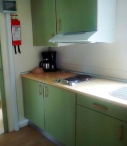 a kitchen with green cabinets and a stove at Parque de Campismo Orbitur Sao Jacinto in São Jacinto