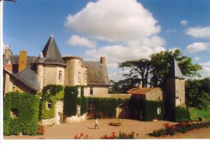 um homem andando em frente a um castelo em Château de Touvois em Maulévrier