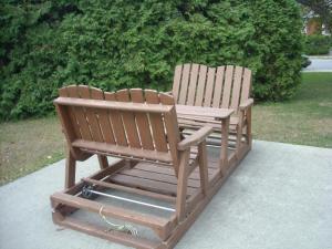 two wooden benches sitting next to each other at Motel le Verseau in Sorel
