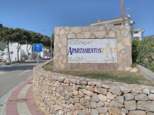 una pared de retención de piedra con una señal en ella en Alpen1 Font Nova, en Peñíscola