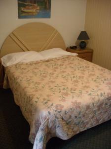 1 dormitorio con 1 cama grande con colcha de flores en Motel le Verseau, en Sorel